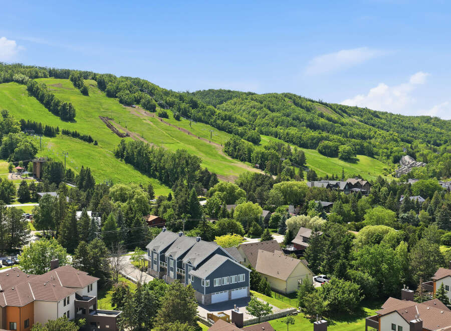 Experience the best of mountain living with this stunning property offering panoramic views of lush green ski slopes and surrounding forests.