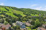 Experience the best of mountain living with this stunning property offering panoramic views of lush green ski slopes and surrounding forests.