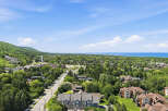 Discover this stunning aerial view showcasing a vibrant community nestled amidst lush greenery and rolling hills.