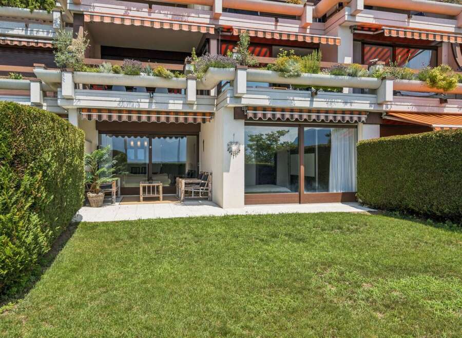 Enjoy outdoor living with this property featuring a lush green lawn and a private patio area perfect for relaxation.