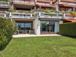 Enjoy outdoor living with this property featuring a lush green lawn and a private patio area perfect for relaxation.
