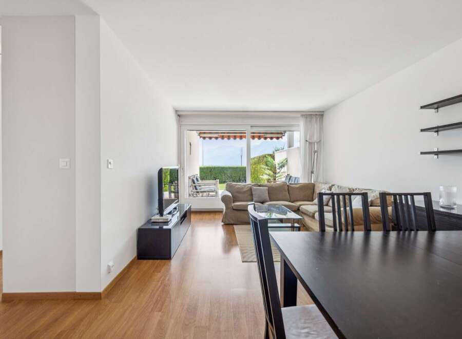 Experience breathtaking views from this spacious living and dining area, featuring a large sectional sofa and a modern dining set.