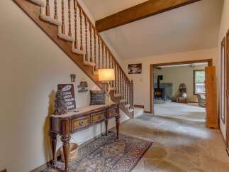 Step into a warm and inviting entryway featuring a rustic wooden console table adorned with charming cabin-themed decor.