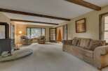 Experience rustic charm in this inviting living room, featuring exposed wooden beams and a cozy fireplace.