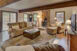 Experience cozy living in this inviting living room, featuring a prominent stone fireplace with a wood-burning stove, perfect for chilly evenings.