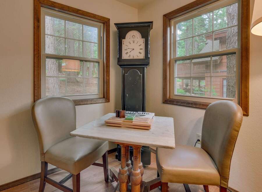 This charming corner features a classic grandfather clock and two comfortable chairs, perfect for a cozy reading nook or a quiet game of cards.