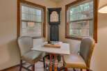 This charming corner features a classic grandfather clock and two comfortable chairs, perfect for a cozy reading nook or a quiet game of cards.