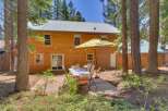 Enjoy outdoor dining and relaxation in this charming backyard oasis, complete with a wooden deck and a picnic table set under a large umbrella.