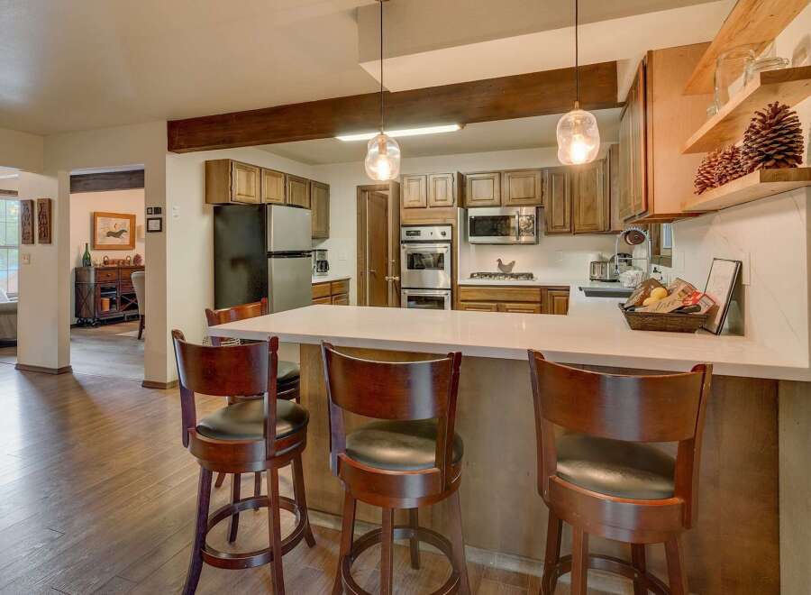 This spacious kitchen boasts beautiful wooden cabinetry and a large island with seating, perfect for casual dining and entertaining.