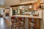 This spacious kitchen boasts beautiful wooden cabinetry and a large island with seating, perfect for casual dining and entertaining.