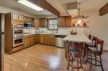 Discover this charming kitchen featuring warm wood cabinetry and sleek stainless steel appliances, including a double oven and microwave.