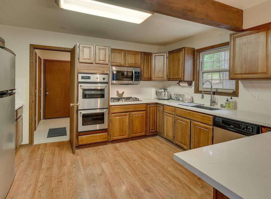 This spacious kitchen boasts beautiful wooden cabinetry and a double oven, perfect for any home chef.