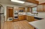 This spacious kitchen boasts beautiful wooden cabinetry and a double oven, perfect for any home chef.