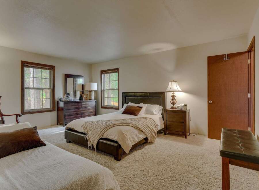 This spacious bedroom features a comfortable king-size bed with plush bedding and a cozy throw blanket, perfect for relaxation.