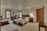 This spacious bedroom features a comfortable king-size bed with plush bedding and a cozy throw blanket, perfect for relaxation.