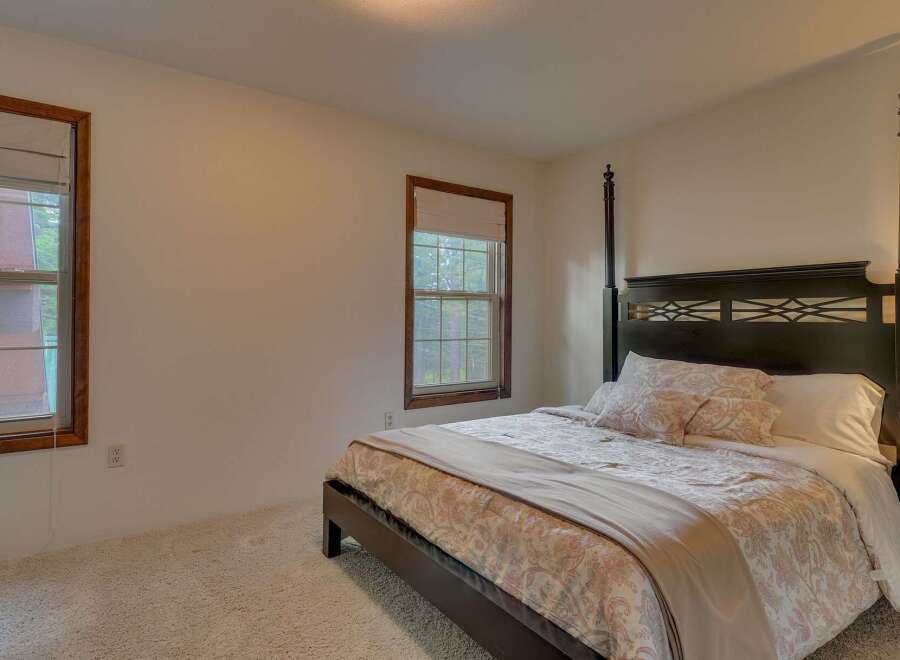 This charming bedroom features a comfortable queen-size bed with a decorative headboard and plush bedding.