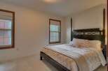 This charming bedroom features a comfortable queen-size bed with a decorative headboard and plush bedding.