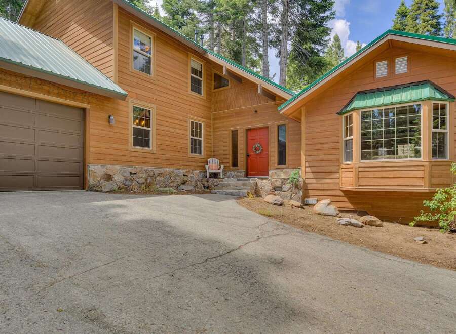Nestled amidst tall pines, this charming wooden home offers a serene retreat.