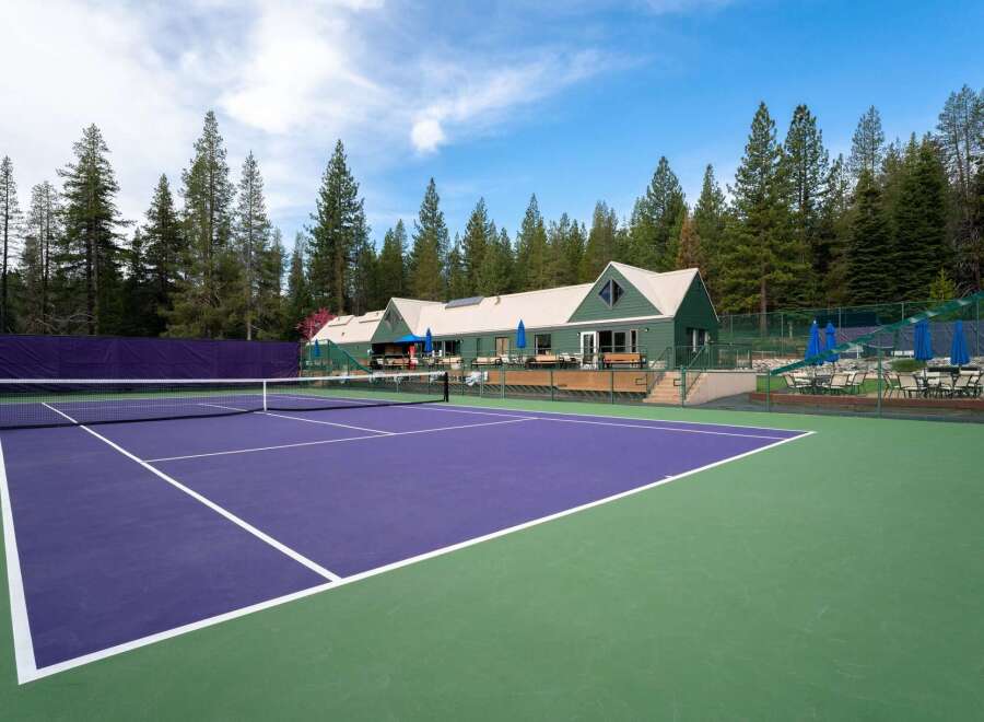 Experience luxury living with this stunning property featuring a vibrant purple tennis court, perfect for enthusiasts.