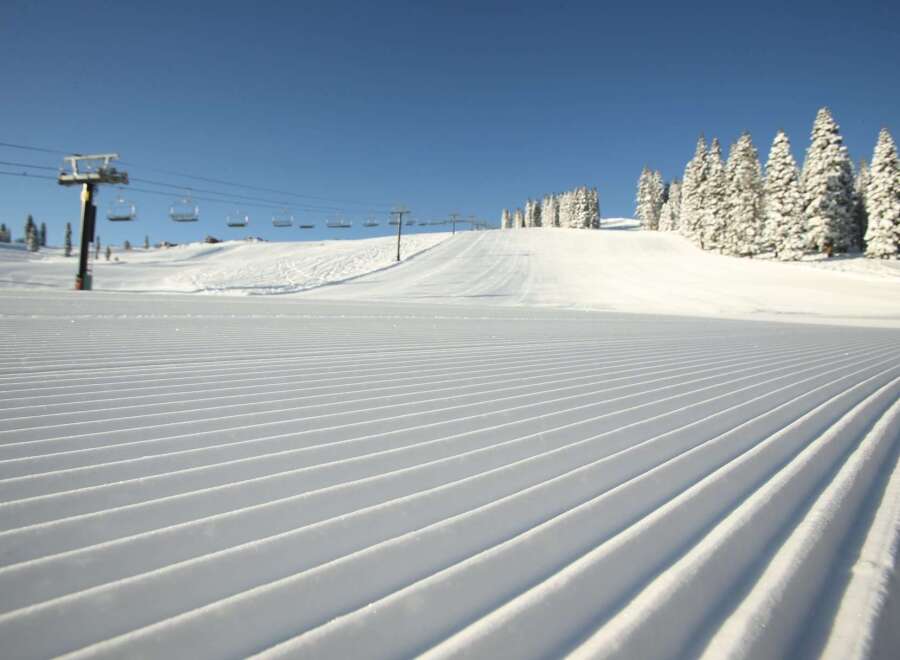 Experience the pristine beauty of a freshly groomed ski slope, perfect for a day of exhilarating winter sports.
