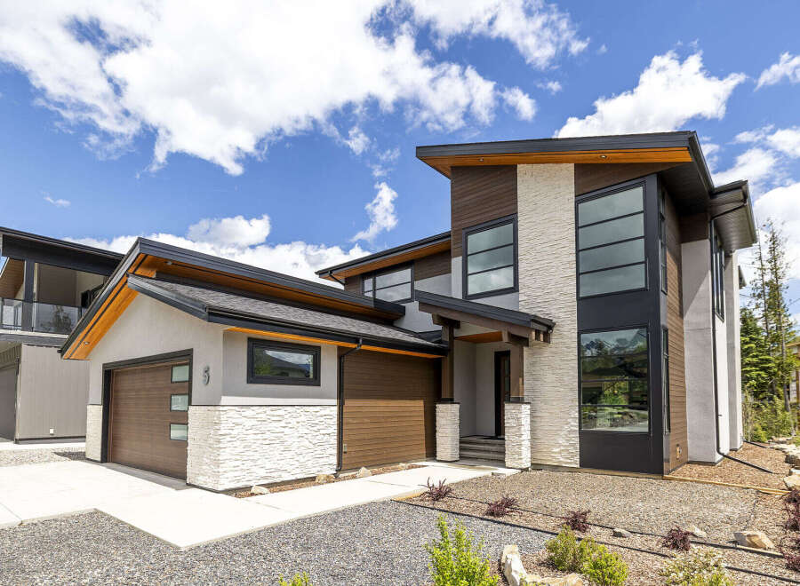 Experience modern luxury in this stunning multi-story home, featuring a striking architectural design with a mix of wood, stone, and stucco finishes.