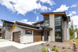 Experience modern luxury in this stunning multi-story home, featuring a striking architectural design with a mix of wood, stone, and stucco finishes.