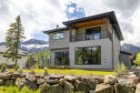 Experience luxury mountain living in this stunning modern home, featuring expansive windows that frame breathtaking views of snow-capped peaks.
