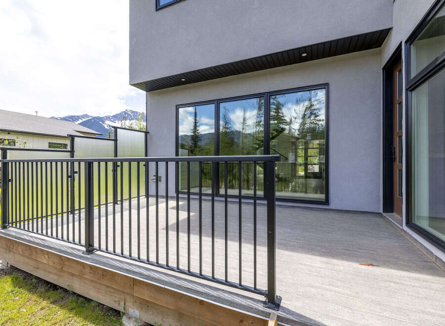 Experience modern living with this stunning property featuring a spacious deck and large windows that offer breathtaking mountain views.