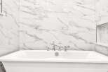 Indulge in luxury with this stunning freestanding bathtub, perfectly complemented by elegant marble-patterned wall tiles.