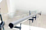 Experience modern living with this stunning staircase featuring a sleek glass railing and a minimalist metal handrail.