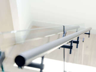 Experience modern living with this stunning staircase featuring a sleek glass railing and a minimalist metal handrail.