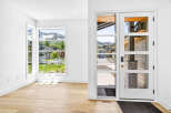 Step into this modern entryway featuring a stunning glass-paneled door and expansive windows that flood the space with natural light.