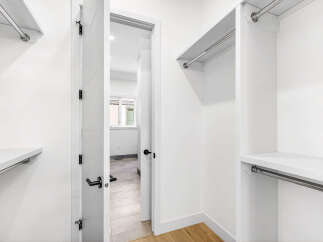 Step into this spacious walk-in closet, featuring ample shelving and hanging space to organize your wardrobe.
