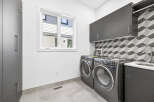 This modern laundry room features sleek dark gray cabinetry, providing ample storage solutions.