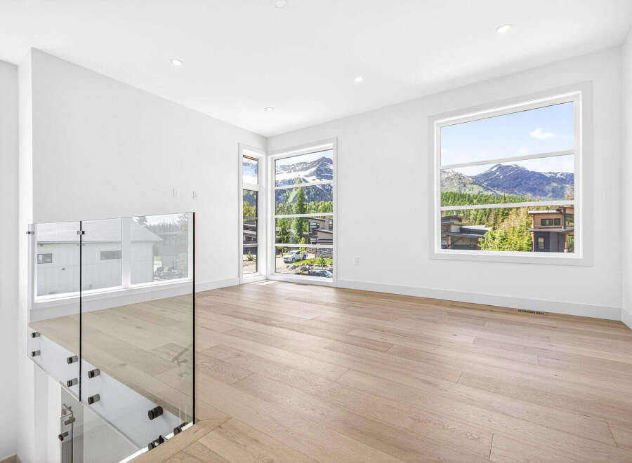 Experience breathtaking mountain views from this modern interior space, featuring expansive windows that flood the room with natural light.