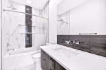 Experience modern luxury in this stunning bathroom, featuring a sleek bathtub and toilet.