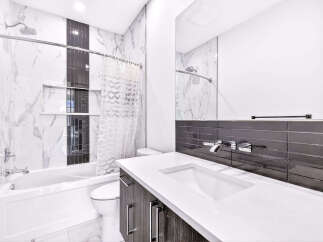 Experience modern luxury in this stunning bathroom, featuring a sleek bathtub and toilet.