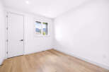 Step into this bright and airy room featuring a modern white door and a large window with stunning mountain views.