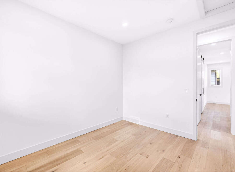 Step into this bright and airy room, featuring pristine white walls and a beautiful light wood floor that creates a warm and inviting atmosphere.