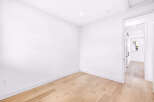Step into this bright and airy room, featuring pristine white walls and a beautiful light wood floor that creates a warm and inviting atmosphere.