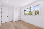 Step into this bright and airy room, featuring a large window that floods the space with natural light and offers stunning views of the surrounding evergreen forest and mountains.
