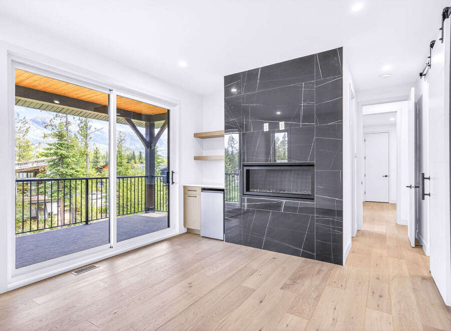 Experience modern living with this stunning room featuring a sleek, dark-tiled fireplace as the centerpiece.