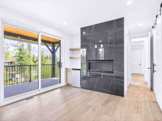 Experience modern living with this stunning room featuring a sleek, dark-tiled fireplace as the centerpiece.