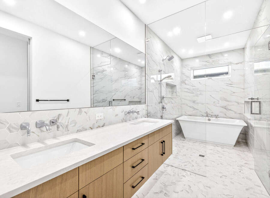 Experience modern luxury in this stunning bathroom, featuring a sleek double vanity with contemporary faucets and ample storage.