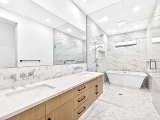 Experience modern luxury in this stunning bathroom, featuring a sleek double vanity with contemporary faucets and ample storage.