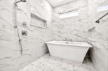 Experience modern luxury in this stunning bathroom, featuring a sleek freestanding bathtub and a separate rainfall shower.