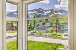 Experience luxury mountain living in this stunning modern home, boasting breathtaking panoramic views of snow-capped peaks and lush green forests.