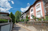 Discover modern living in this charming apartment complex, featuring a vibrant facade with pink and white accents.
