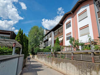 Discover modern living in this charming apartment complex, featuring a vibrant facade with pink and white accents.