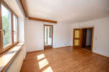 This spacious room features a large wooden-framed window with a wide windowsill, perfect for natural light and decor.